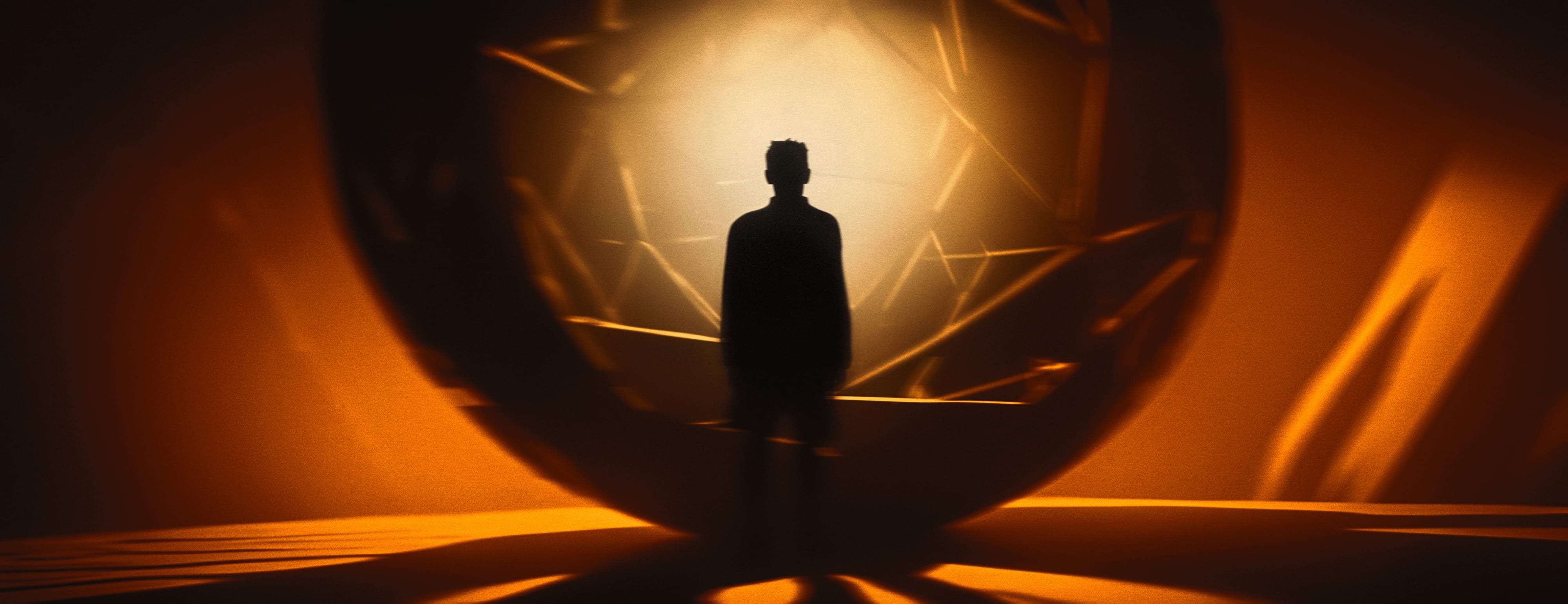 A solitary silhouette standing within an amber spherical chamber of fractured light