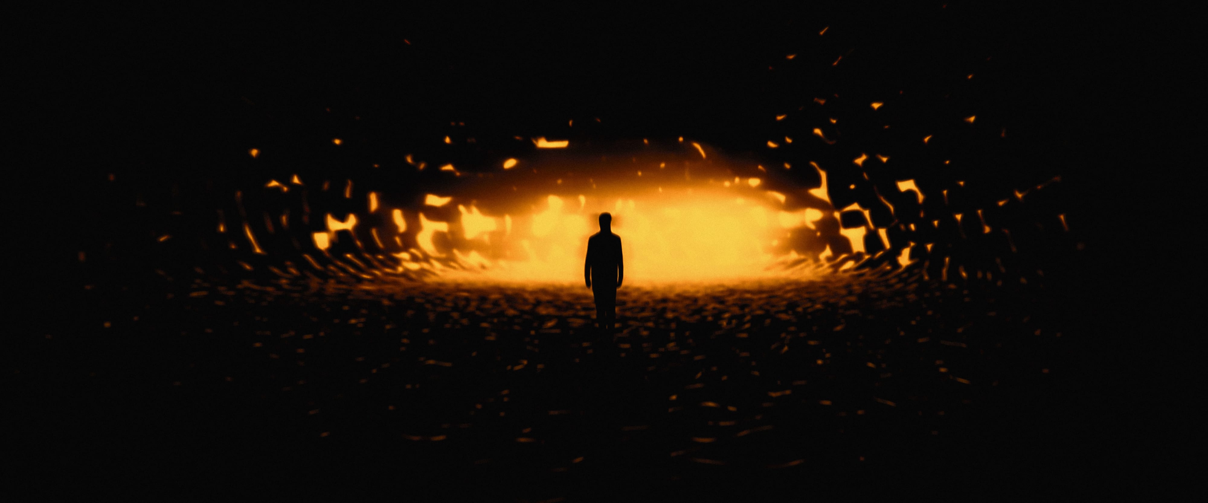 A solitary silhouette moving towards an intense orange field through a dark fragmented environment