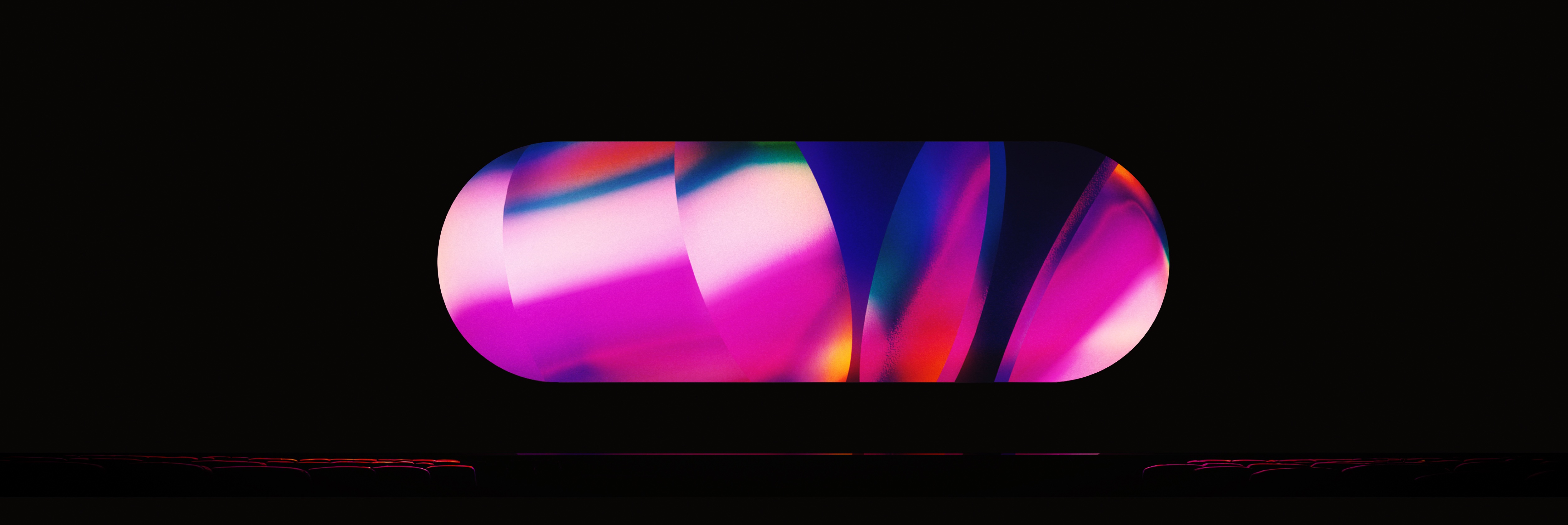 A luminous magenta, blue and green optical field held above a faint linear structure on black