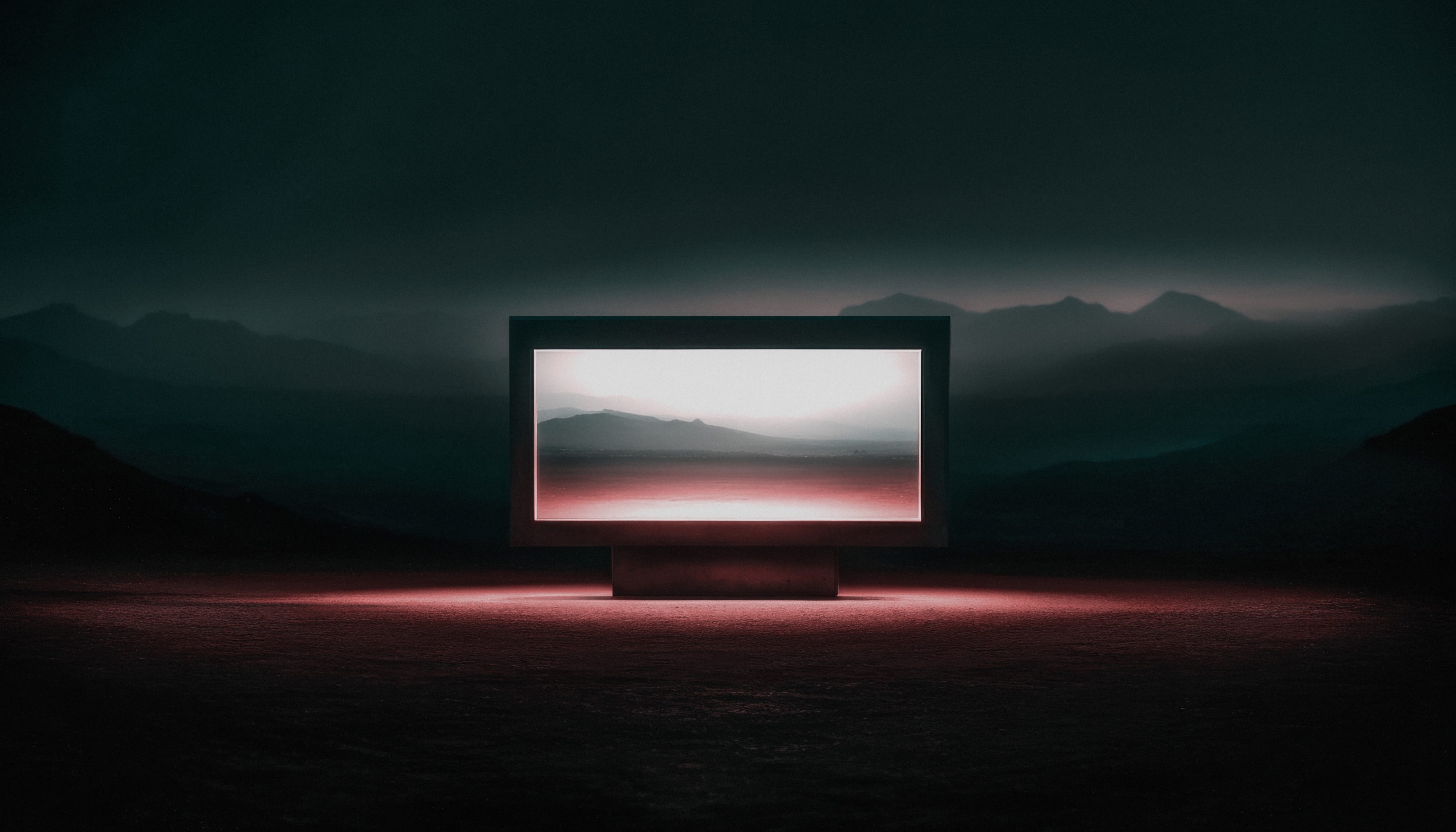 Illuminated image box set within a dark mountainous horizon