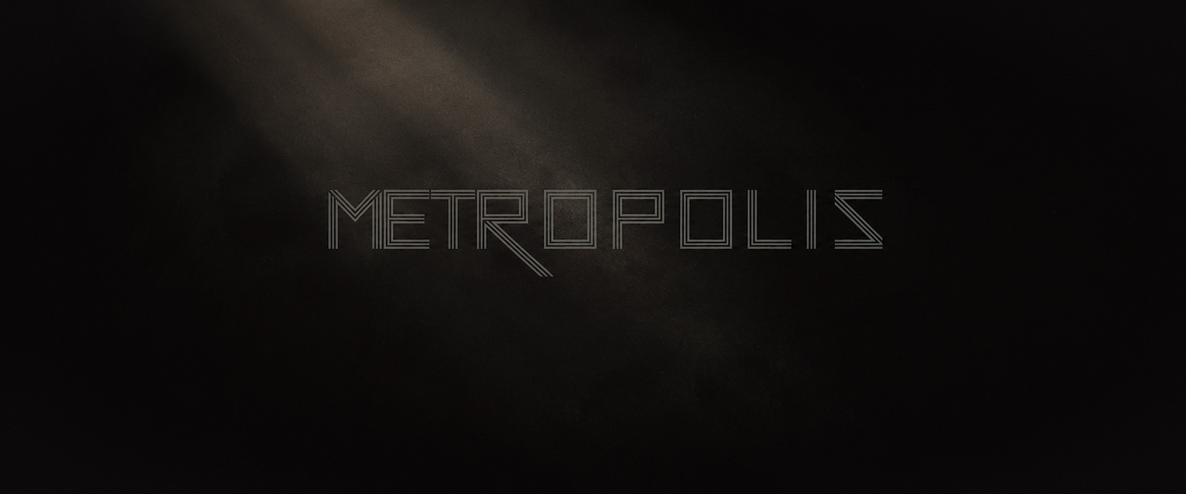 Restrained METROPOLIS wordmark emerging through a dark atmospheric field