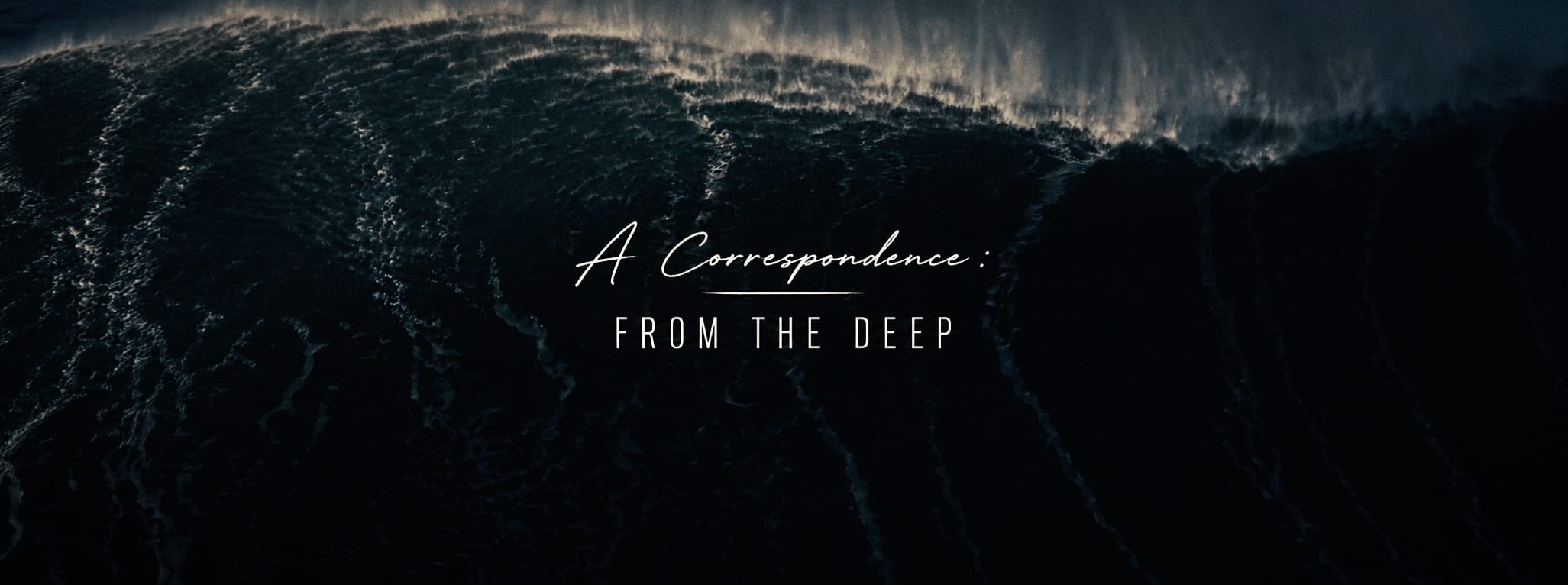 A quiet central title lock-up held small within the scale of a dark aerial ocean wave