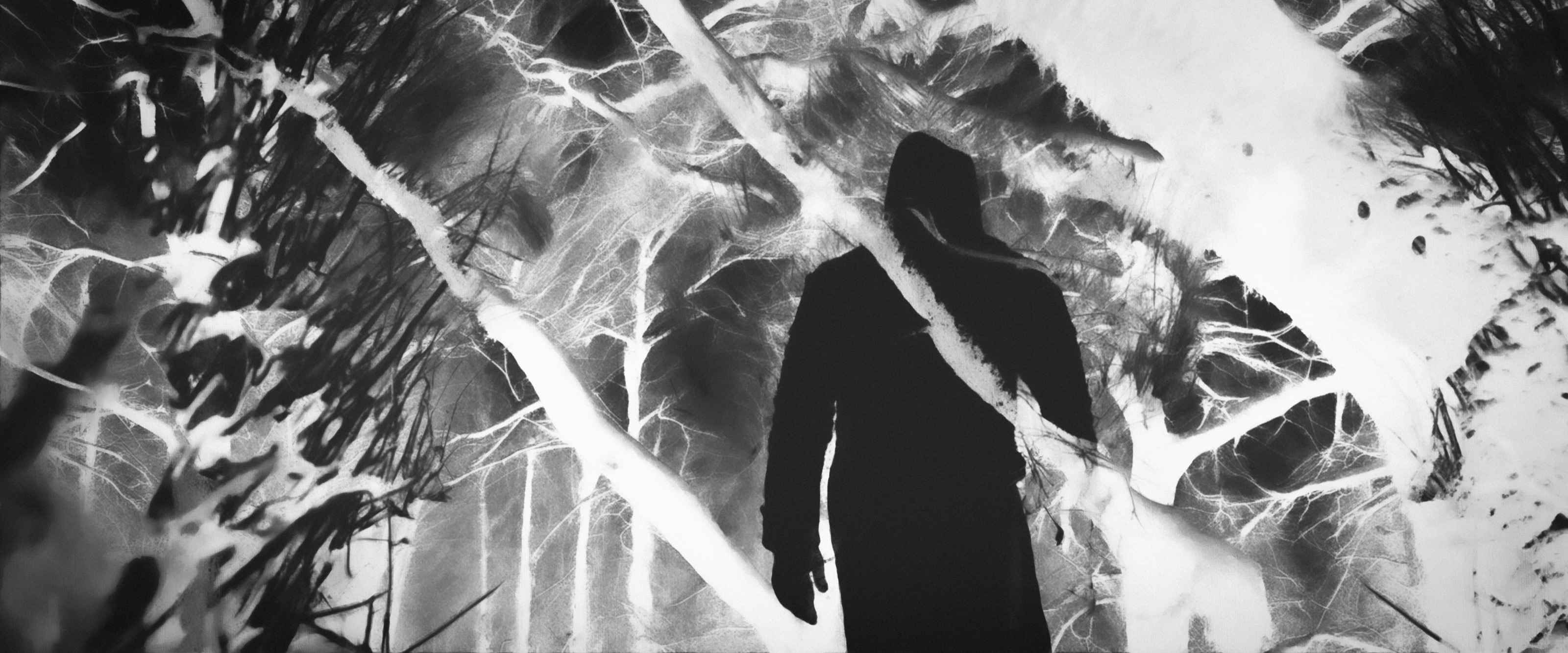 A solitary dark figure framed by storm-torn monochrome coastal dunes
